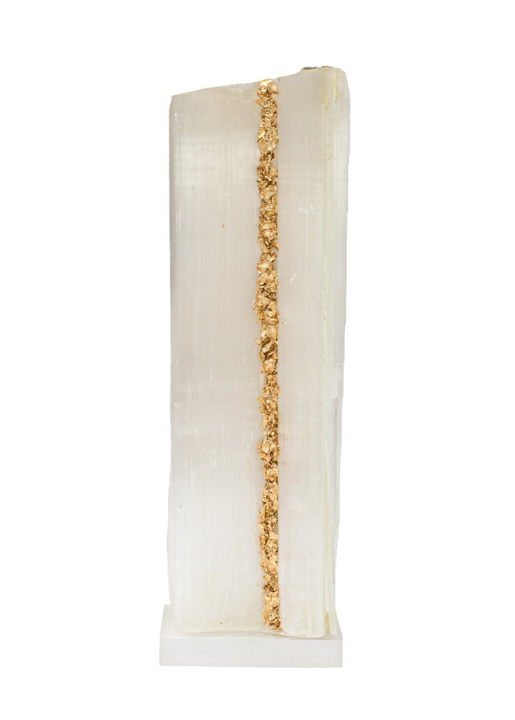 Ruler Selenite with gold leaf on a Lucite base. Selenite logs are single, prismatic selenite crystals from Morocco that were formed in extensive beds by the evaporation of ocean brine. This mineral is characterized by a silky, pearly luster called satin spare. It is then lined with gold leaf which contrasts beautifully with the sleek selenite.