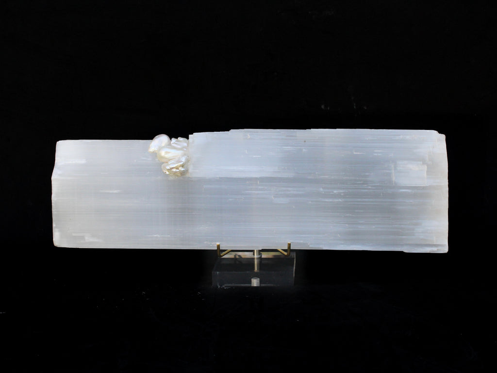 A single selenite log with natural-forming baroque pearls on a custom lucite stand.