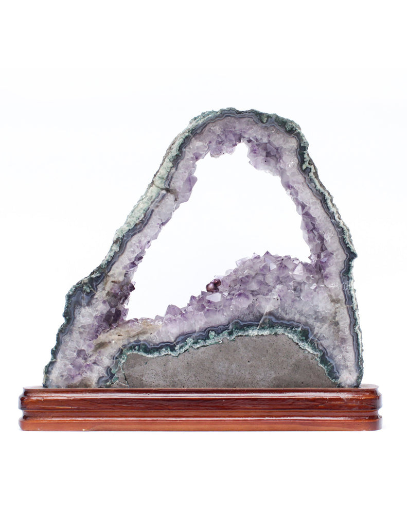 Amethyst slice with a baroque natural forming pearl on a polished wood base.
