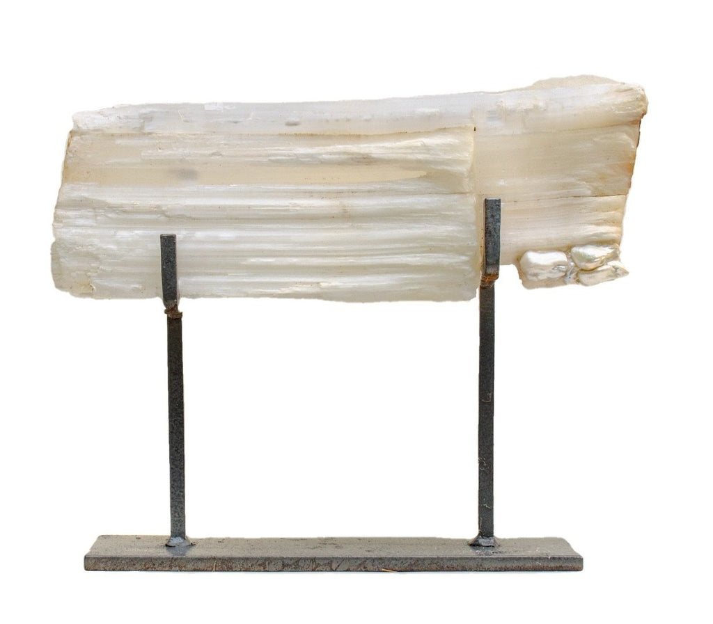 A single selenite log with natural-forming baroque pearls on a custom hammered metal stand. 
